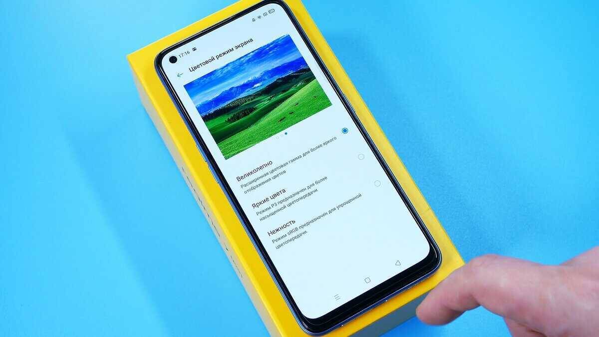 Экран смартфона Realme с настройками цветового режима на синем фоне