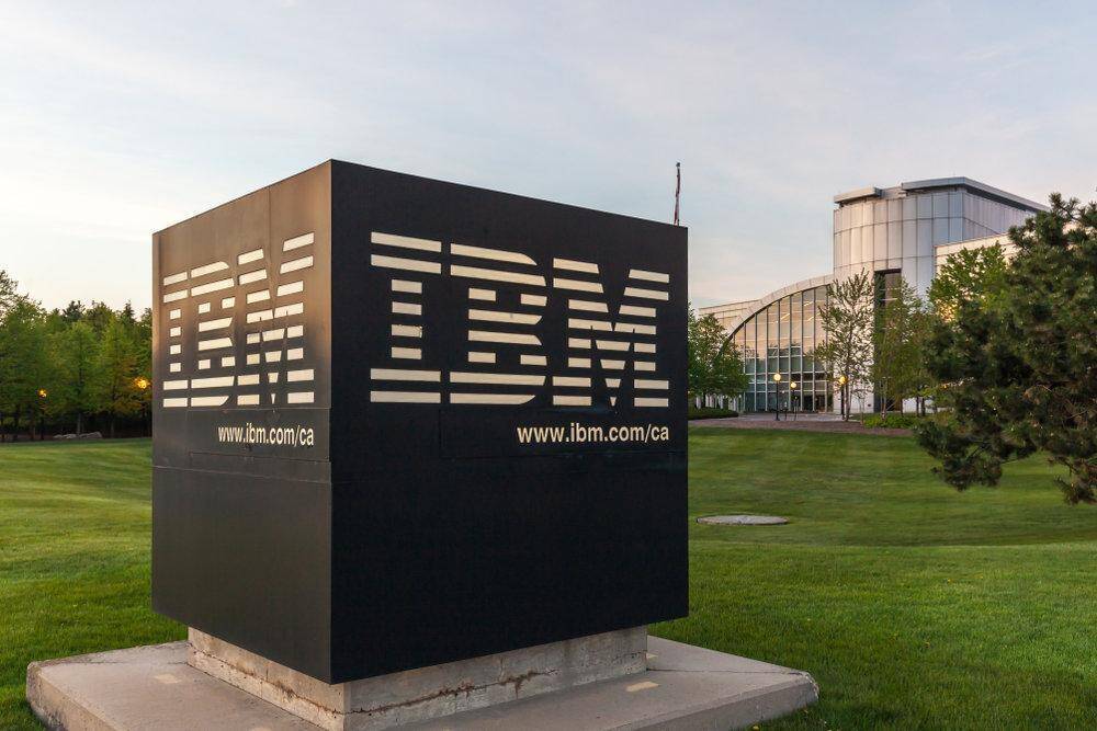 Крупный знак IBM на зеленой лужайке у здания