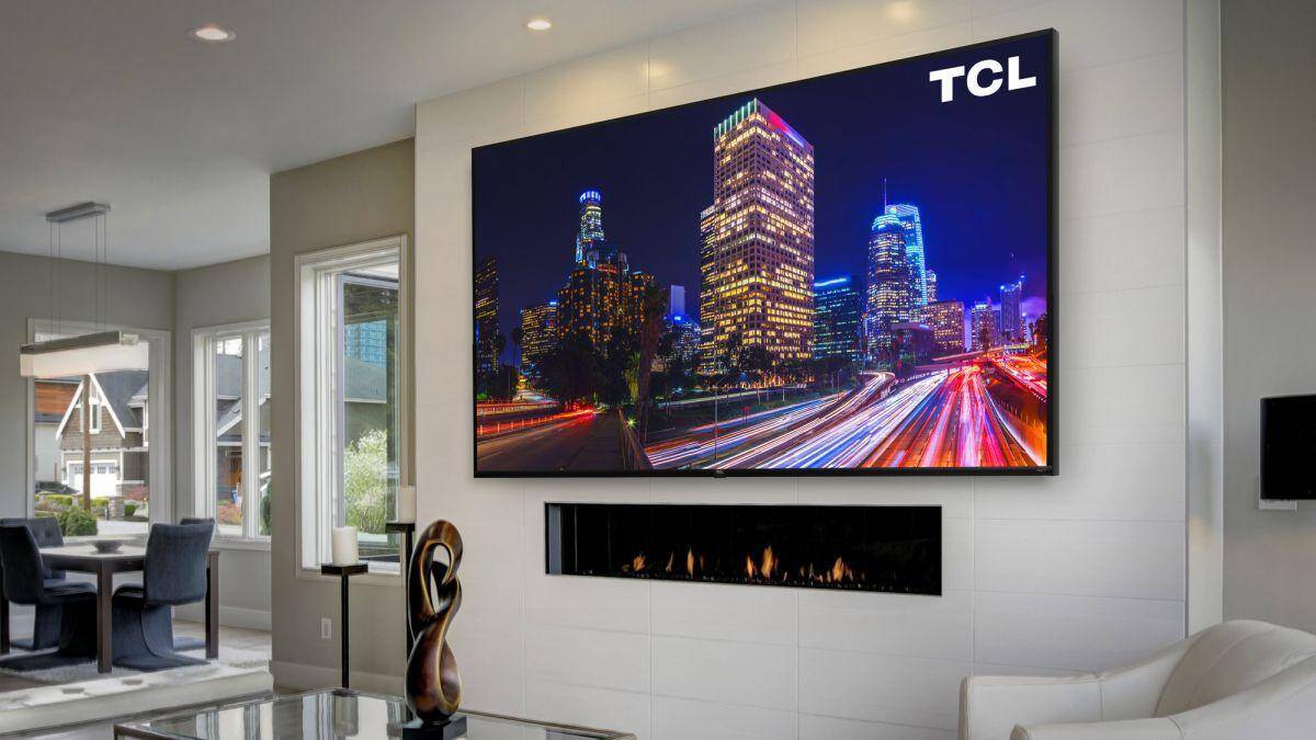Интерьер комнаты с телевизором TCL и камином, крупный экран с ночным городом Google TV