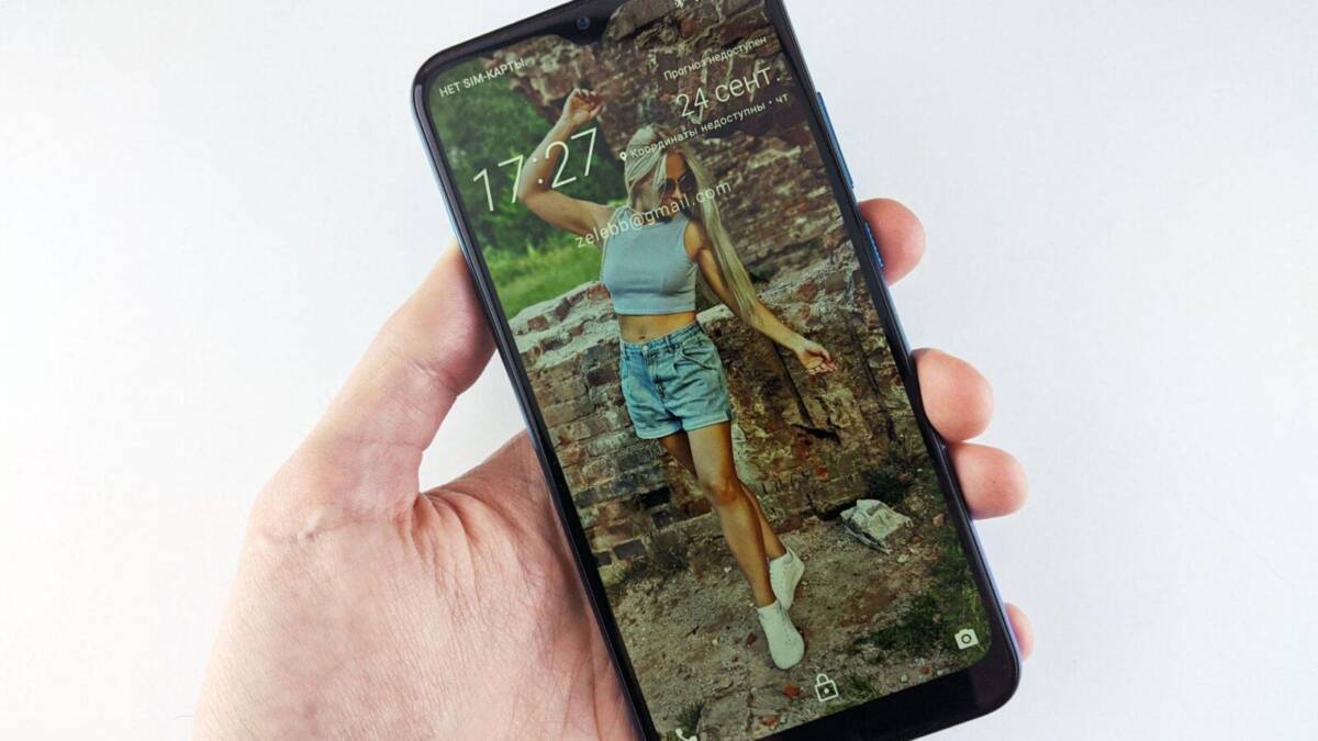 Мужчина держит смартфон HTC Wildfire E2 Plus с 6,82-дюймовым дисплеем и изображением на экране