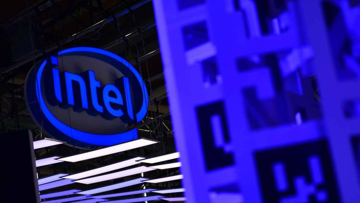 Логотип Intel на фоне светящейся выставочной экспозиции, связанной с майнинг-чипом для биткойнов
