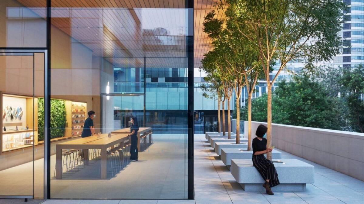 Осенью состоится самая масштабная презентация в истории Apple 4 Люди в кафе на открытой террасе с деревьями и стеклянной стеной