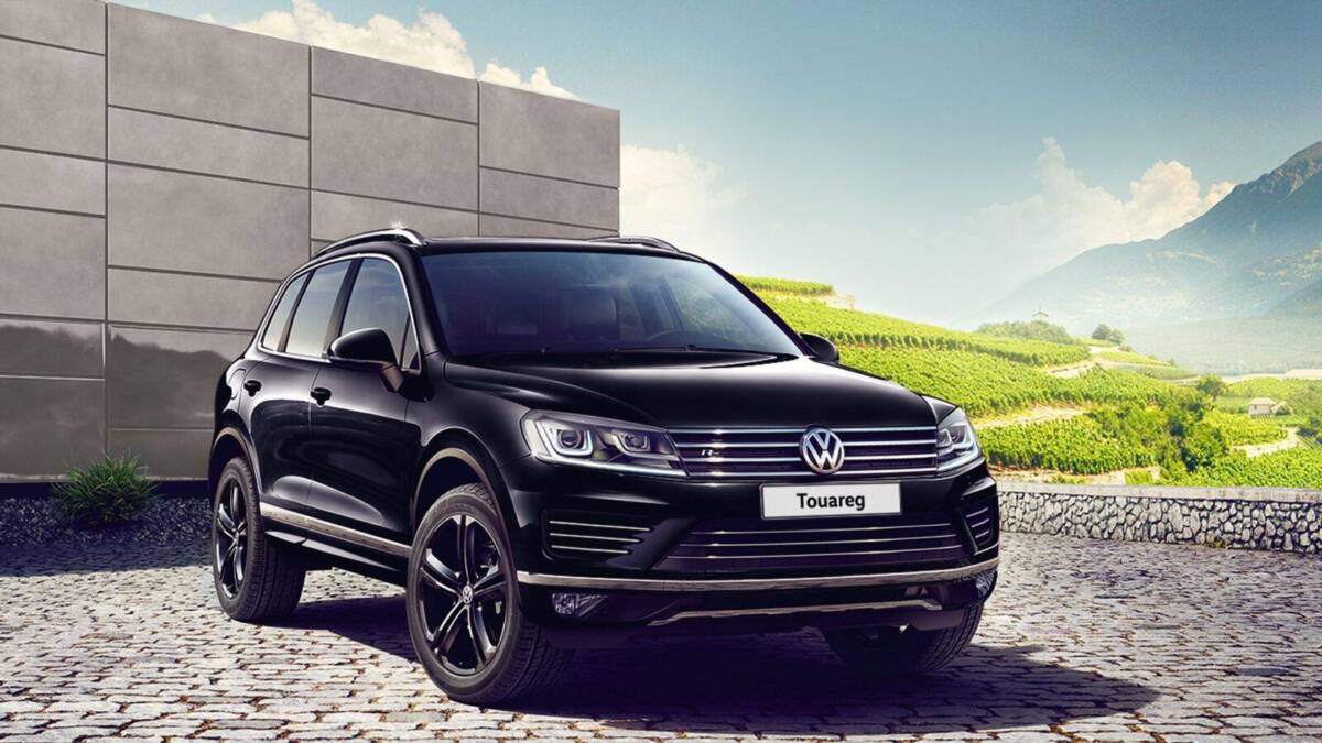 У Volkswagen Touareg обновилось базовое и опциональное оснащение 7 Черный Volkswagen Touareg из переднего ракурса на каменной площади