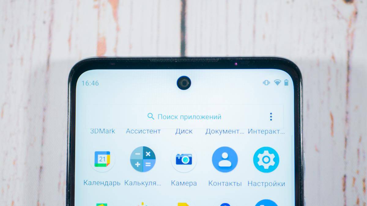 Экран смартфона Moto G60 с иконками приложений на фоне светлой стены