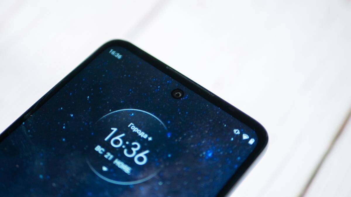 Экран смартфона Moto G60 с круглым временем и иконками уведомлений