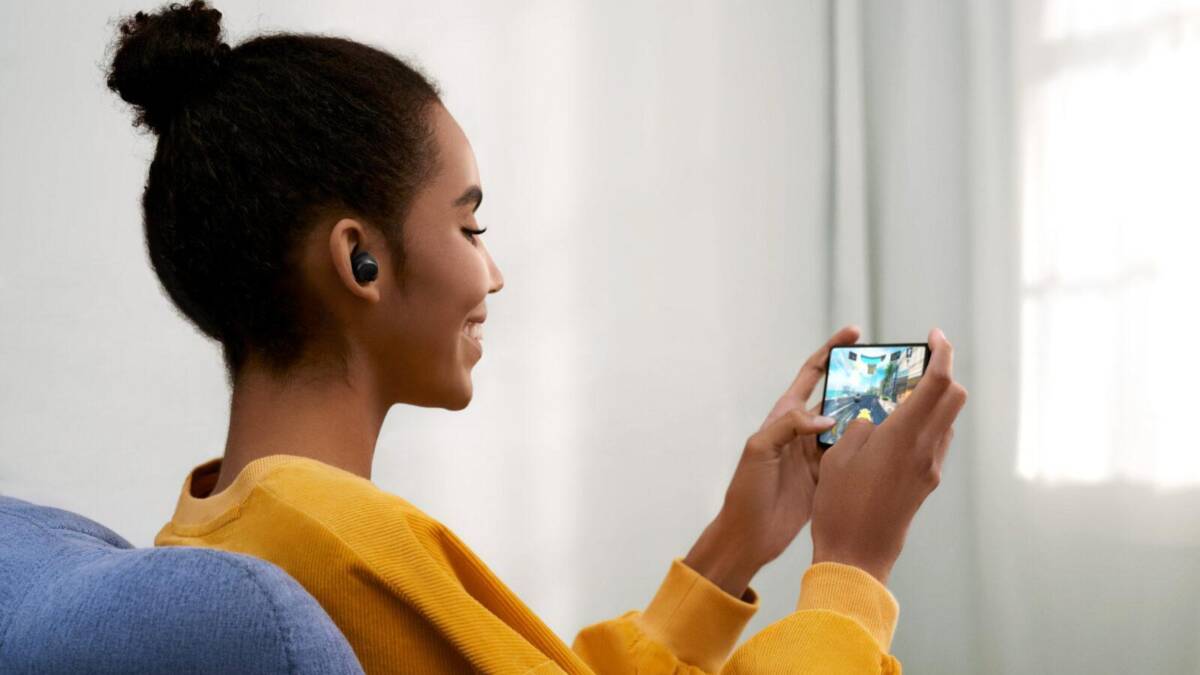Девушка с наушниками Redmi Buds 3 Lite держит смартфон