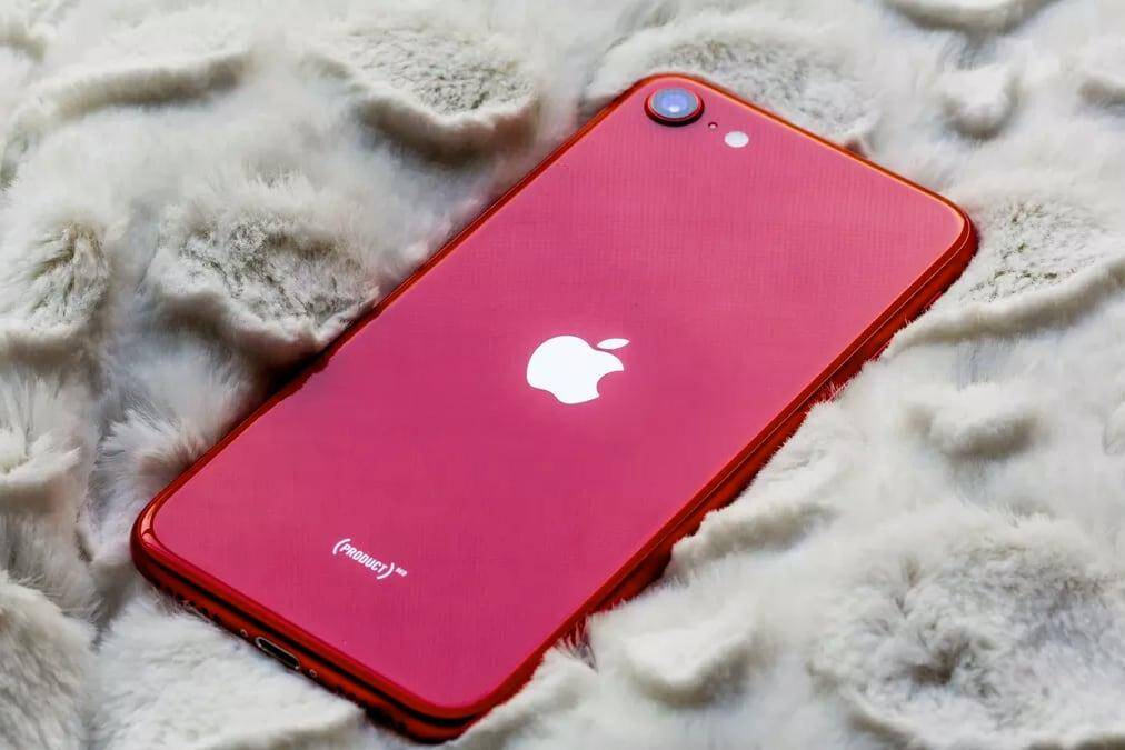 Красный iPhone SE 2023 модель на мягкой поверхности