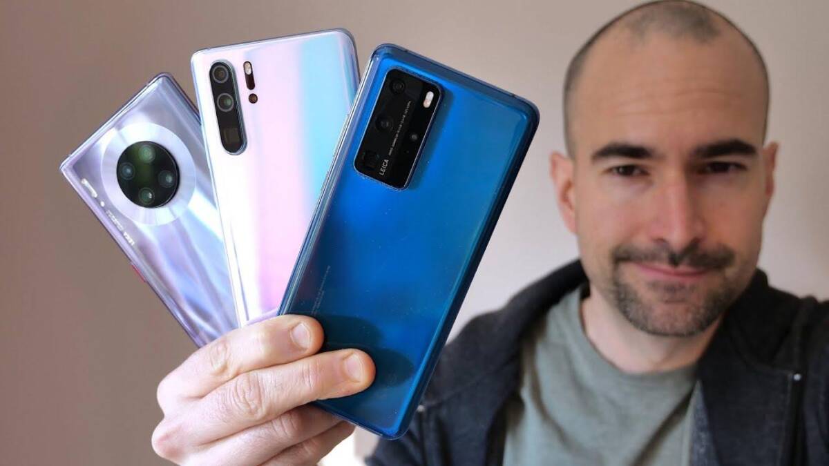Huawei выпустит новый смартфон с большим дисплеем и 108-Мп камерой 5 Человек держит три Huawei смартфона с крупными камерами