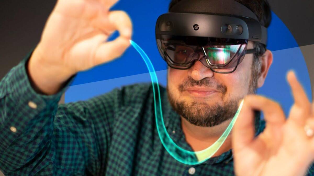 Мужчина в AR-очках Microsoft и Qualcomm на CES 2022 демонстрирует голографическую линию