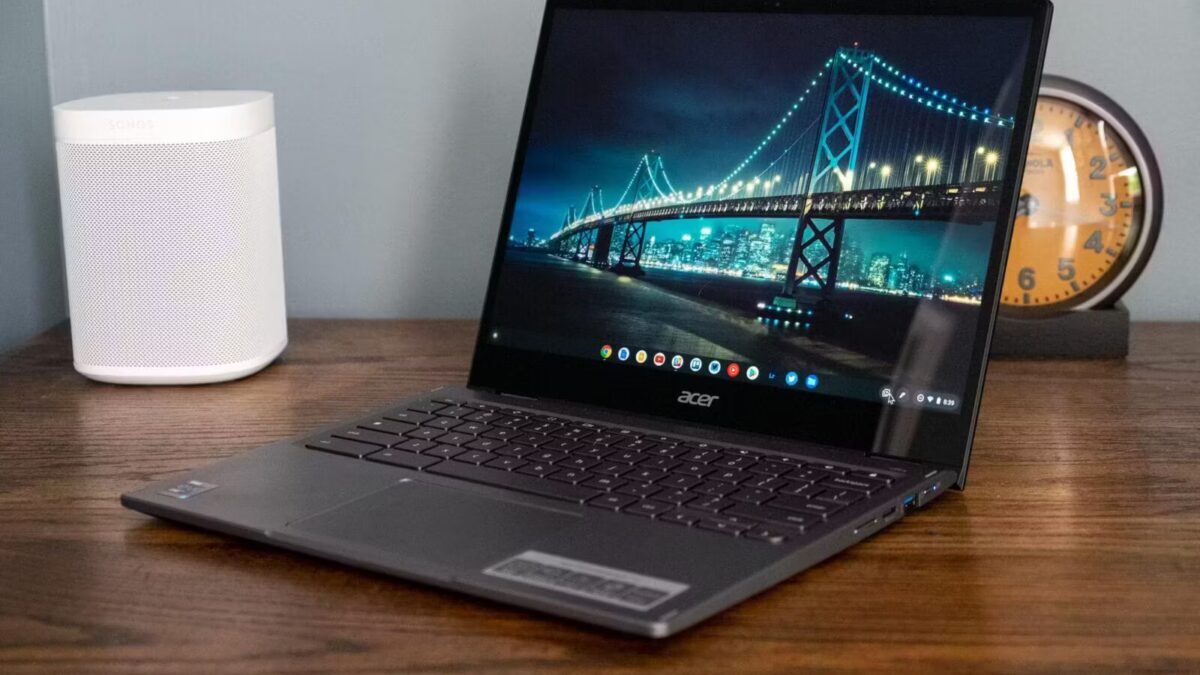 Ноутбук Acer с открытым экраном на деревянном столе, на дисплее изображение моста
