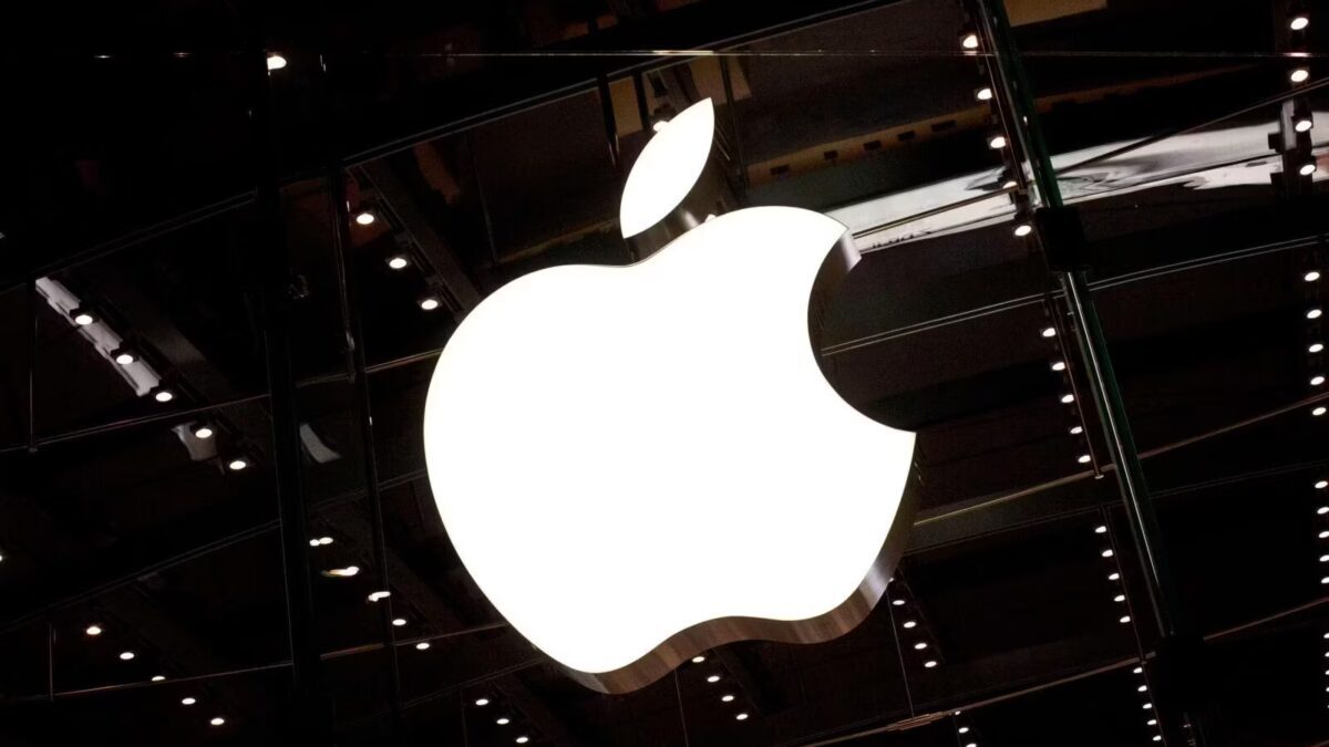 Подсвеченный логотип Apple на фасаде магазина в Нью-Йорке ночью на темном здании