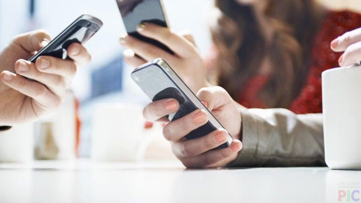 Друзья на встрече используют смартфоны, держат устройства на столе