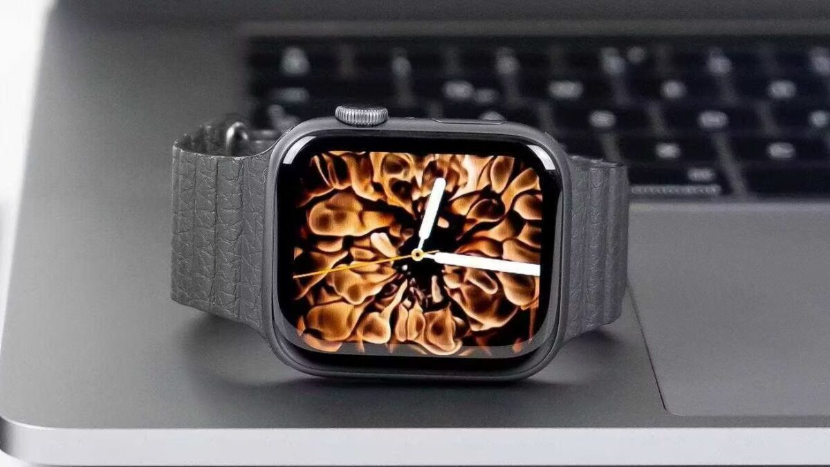 Apple Watch Series 7 лежат на ноутбуке, видна поверхность умных часов и ремешок