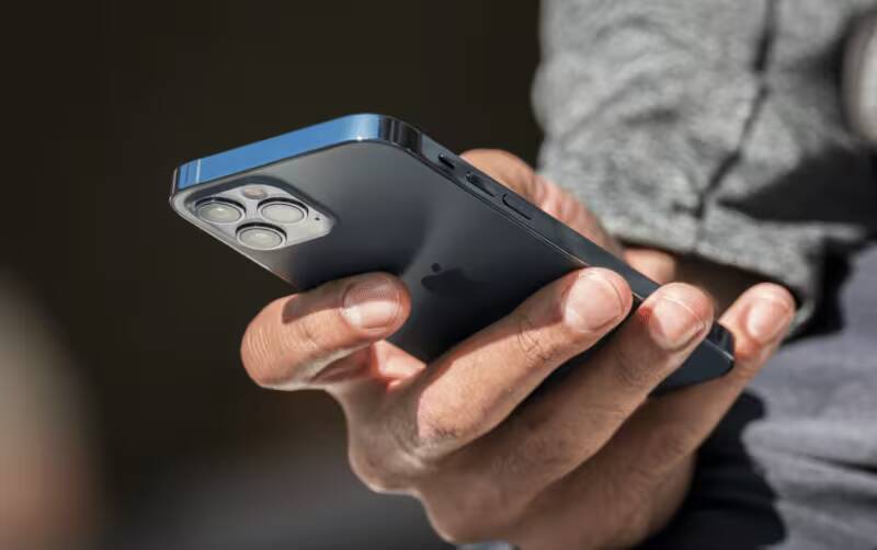 Рука держит iPhone с тройной камерой сзади