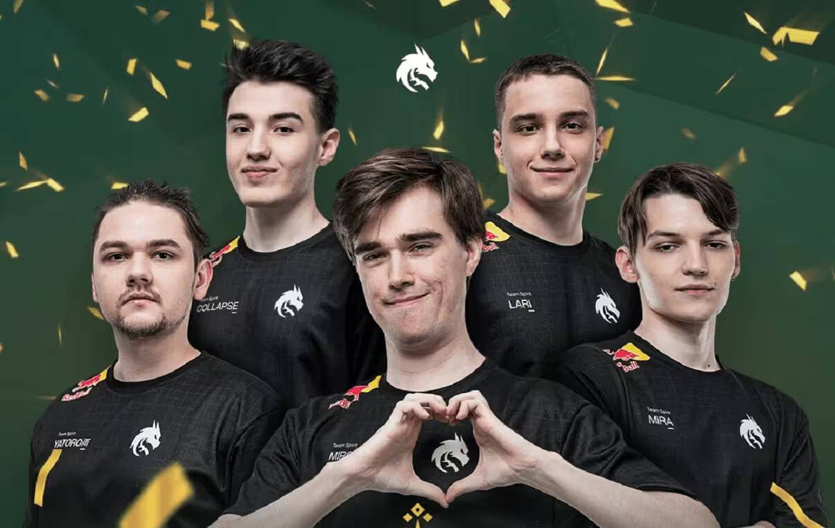 Группа игроков Team Spirit в черных футболках с логотипом на фоне конфетти