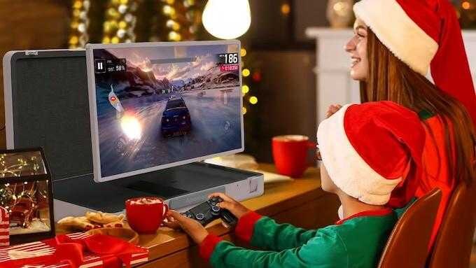 Детский и взрослый смотрят игровой монитор PackGo в новогодней обстановке