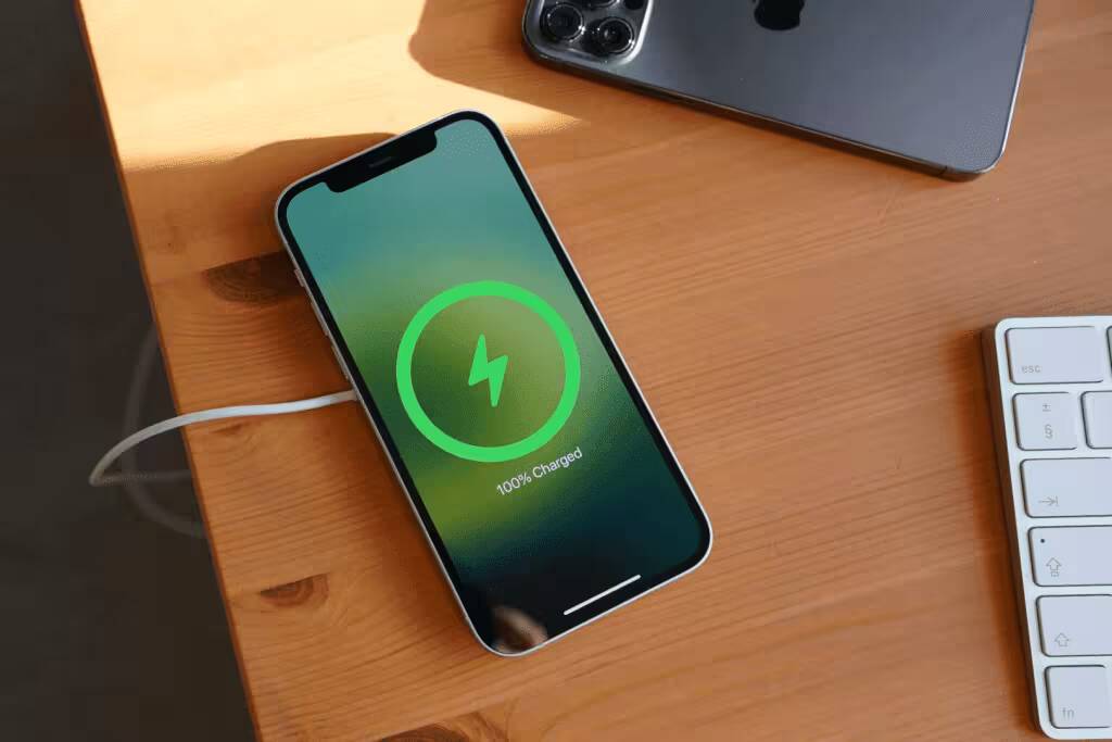 10 мер по защите iPhone от перегрева 3 Айфон заряжается от кабеля на деревянном столе