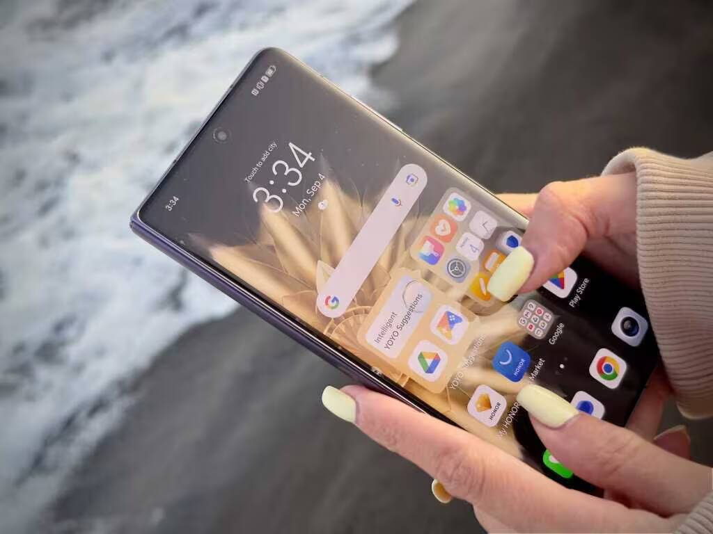 Складной смартфон Honor Magic V2 в руке возле моря