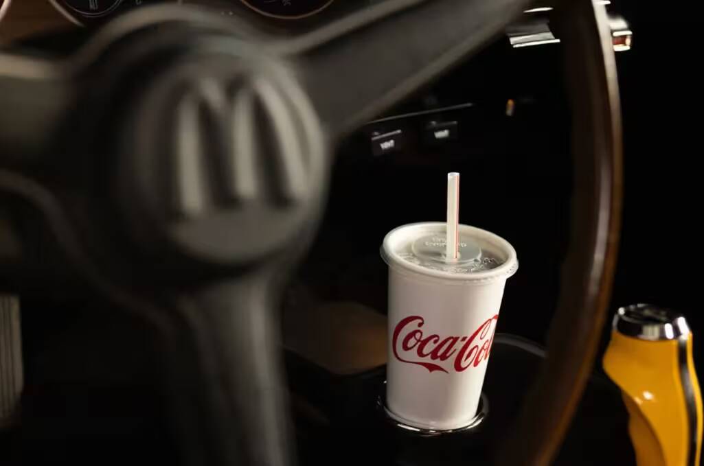 Кофе в стакане Coca-Cola на автомобиле руля
