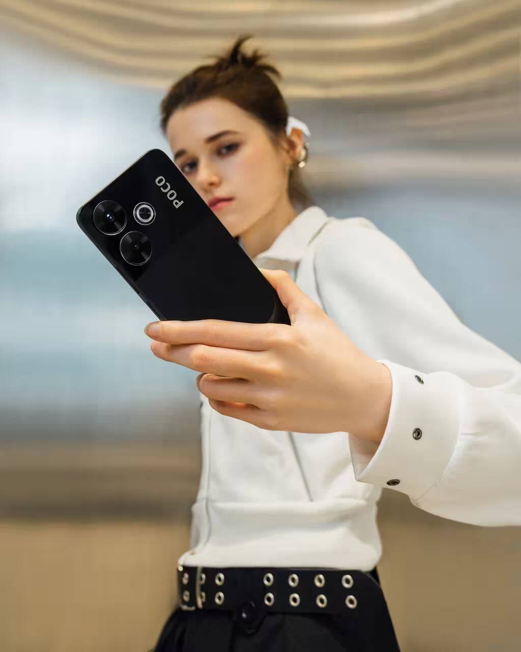 Девушка держит смартфон Poco M6 крупным планом