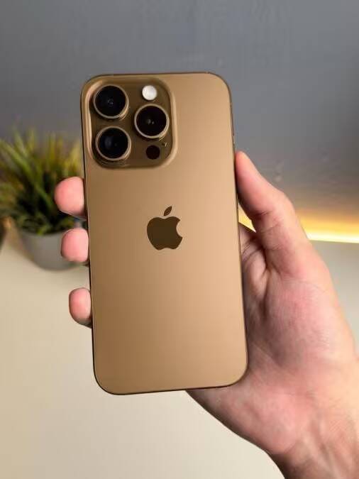 Золотой iPhone 16 Pro с тройной камерой и логотипом Apple на задней панели