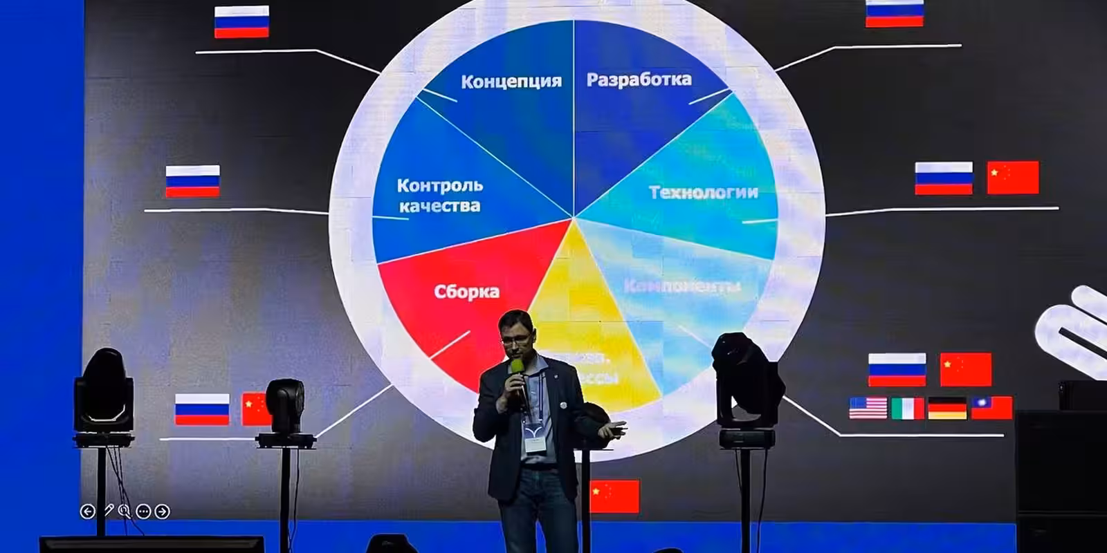 Спикер с микрофоном на XIX Международной конференции прокатных компаний у экрана с диаграммой