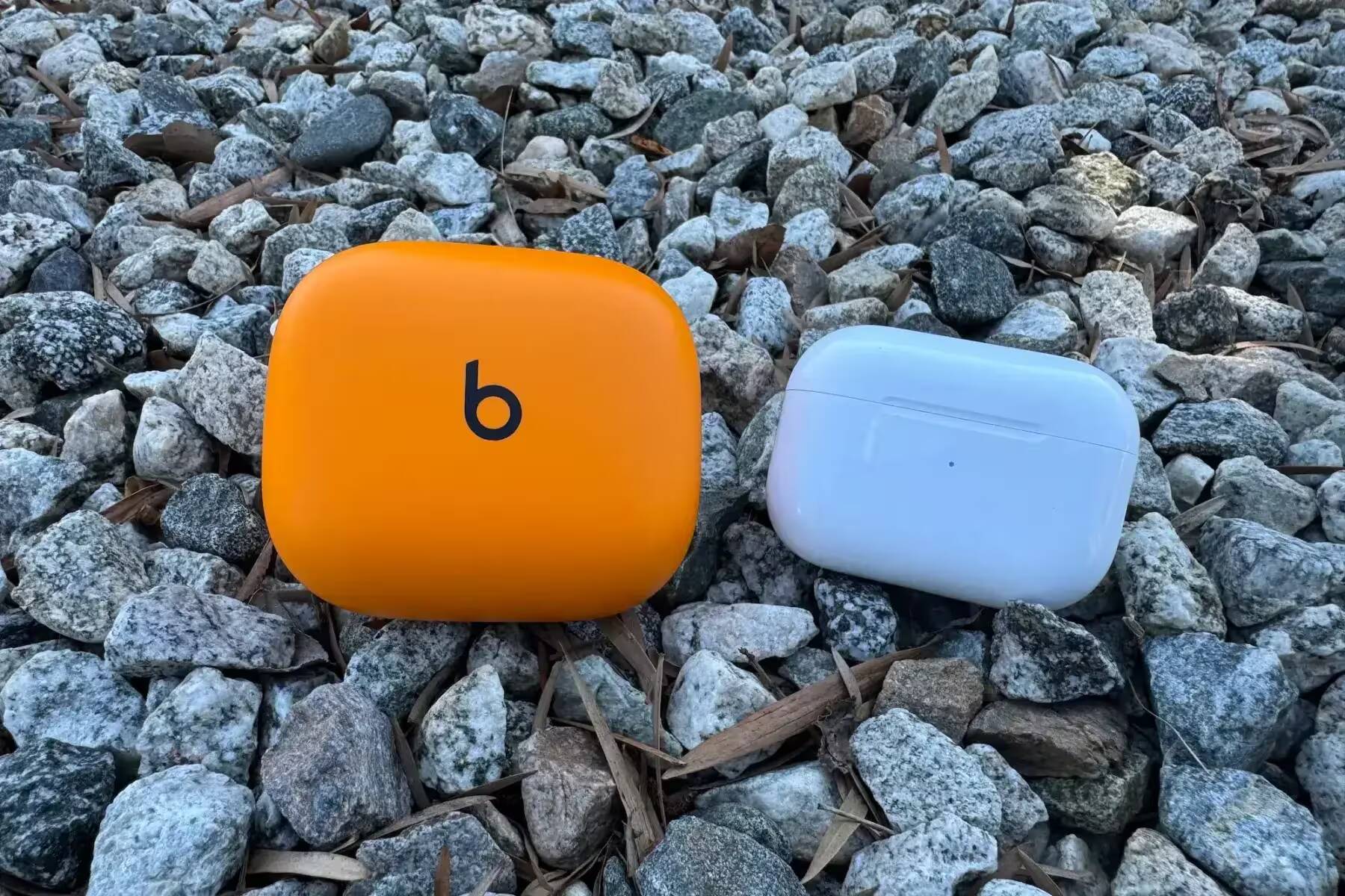 Корпус наушников Apple AirPods Pro 2 и Beats Powerbeats Pro 2 на каменистой поверхности