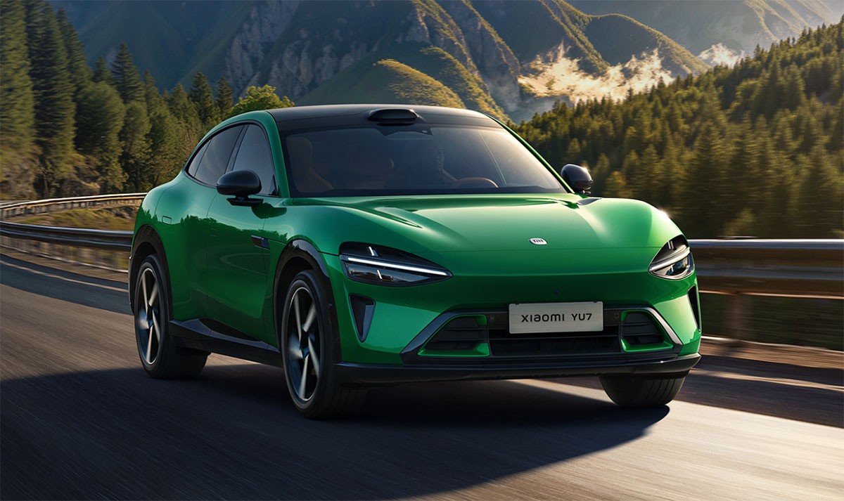 Серый электромобиль Tesla Model Y сбоку на темном фоне