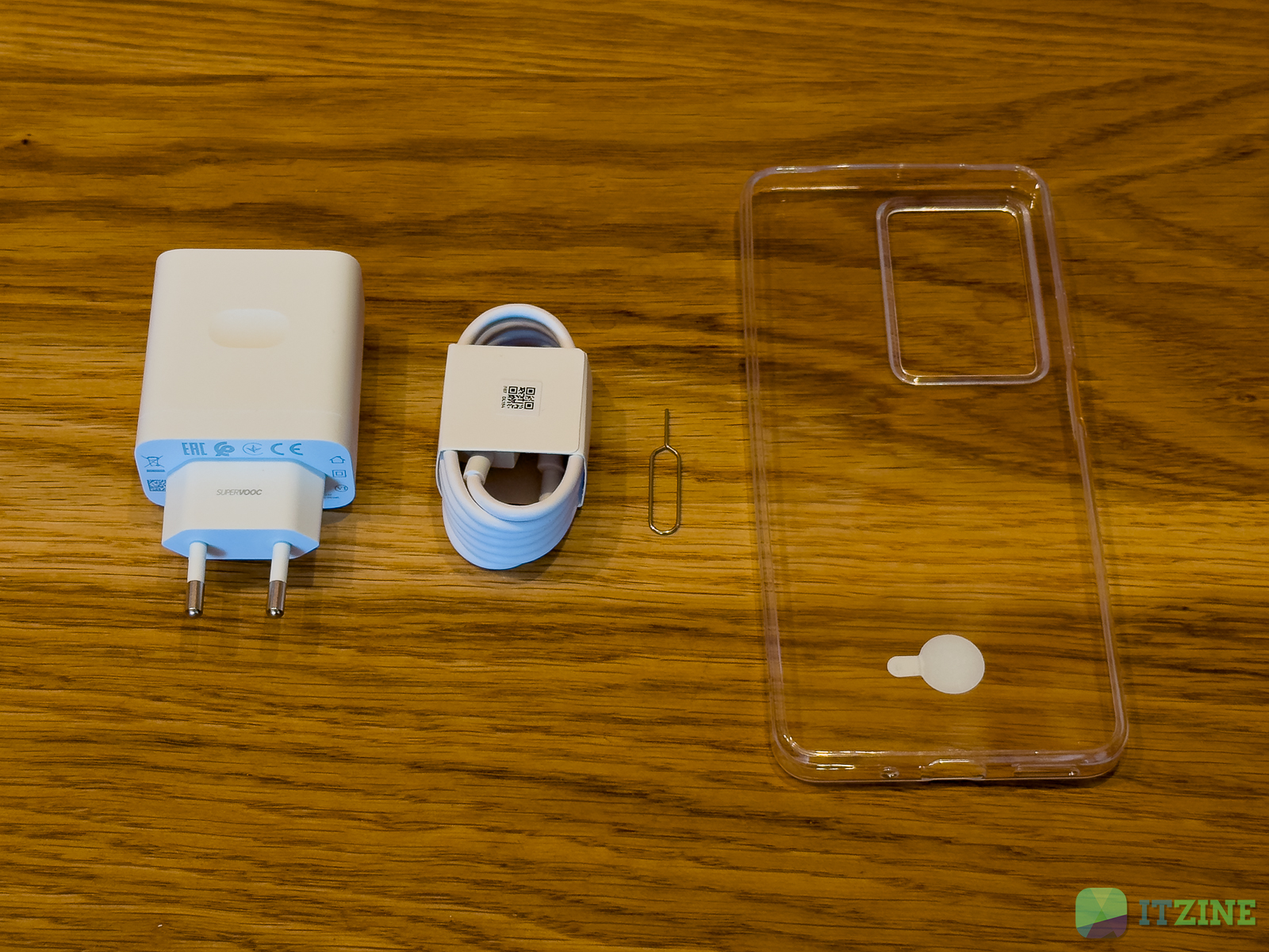 Зарядное устройство и кабель Realme C75 на деревянном столе