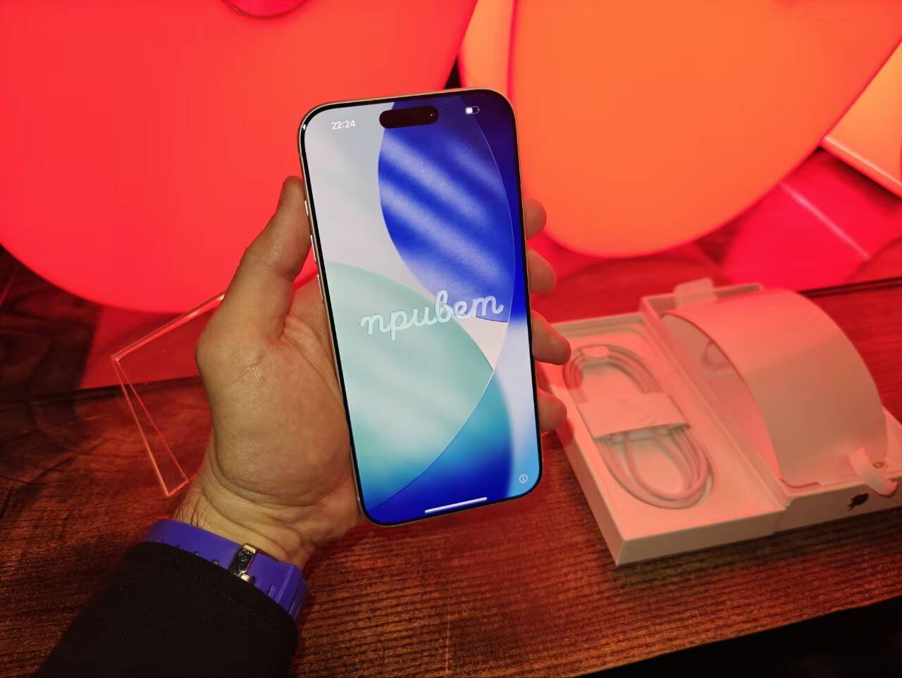 Рука держит iPhone 17 с экраном сверху