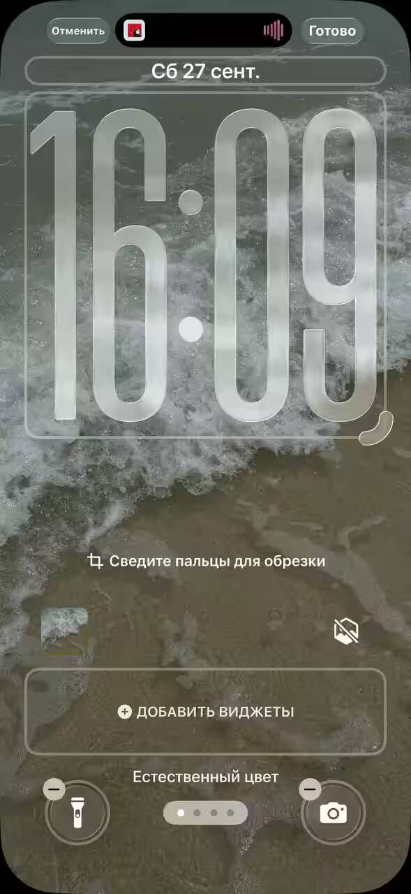 Обзор iOS 26: «жидкое стекло», фон в чате и многое другое 24 Экран iPhone с отображением времени и фона морского пейзажа