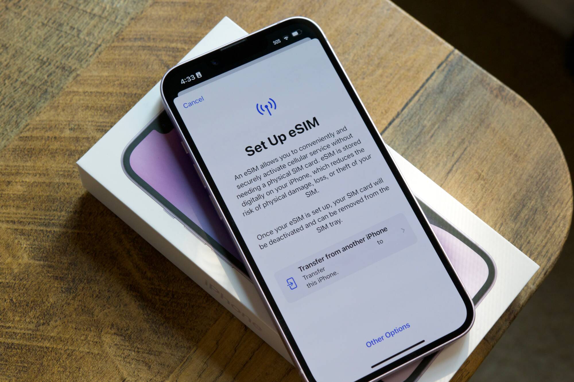 Что такое eSIM и правда ли, что она лучше физической SIM-карты? 2 iPhone 14 демонстрирует экран с настройками eSIM на столе