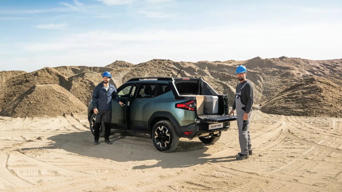 Два мужчины в касках рядом с пикапом Dacia Duster на стройплощадке