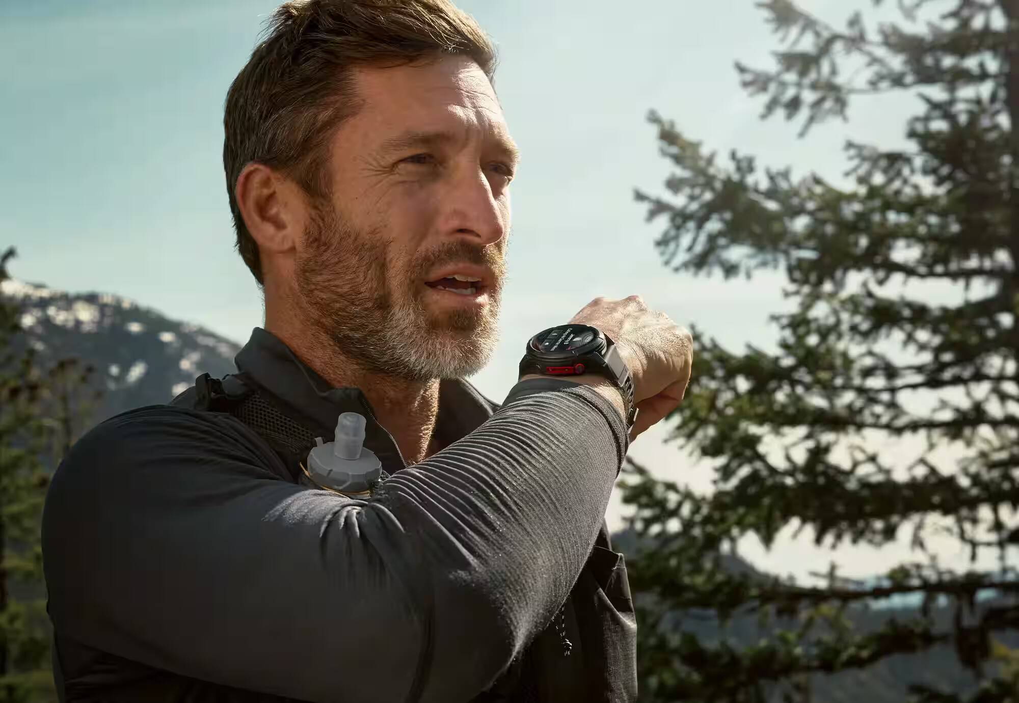 Мужчина смотрит на Garmin Fenix 8 Pro на руке на природе