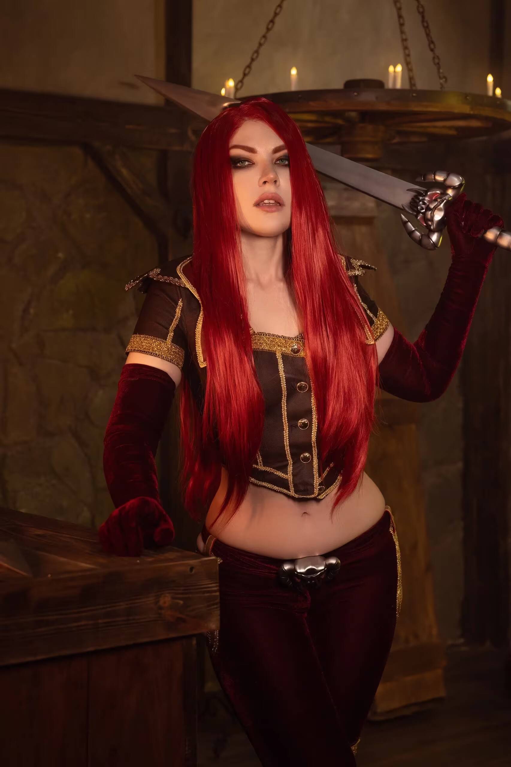 Косплей Катарины из League of Legends с длинными ярко-красными волосами и оружием в руках