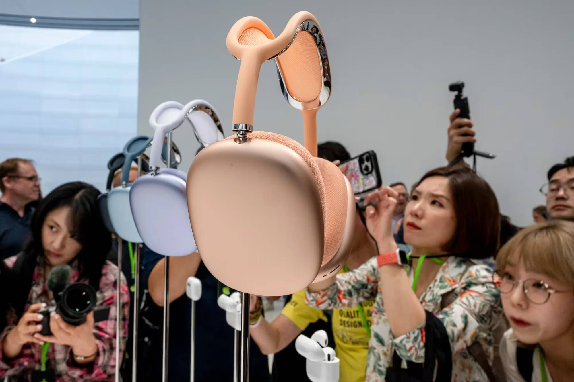 AirPods Max 2 получили новые функции — что изменилось и стоит ли покупать 1 Показаны наушники AirPods Max 2 среди людей на выставке