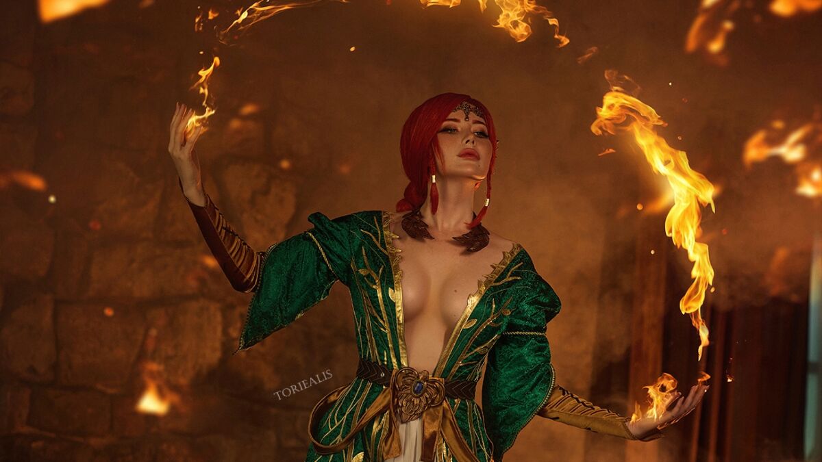 TORIEALIS в образе Трисс Меригольд держит огонь в обеих руках, косплей Ведьмак 3, кольцо огня вокруг фигуры