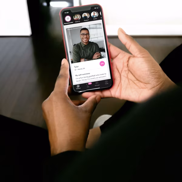 Мужчина держит смартфон с приложением OkCupid на экране