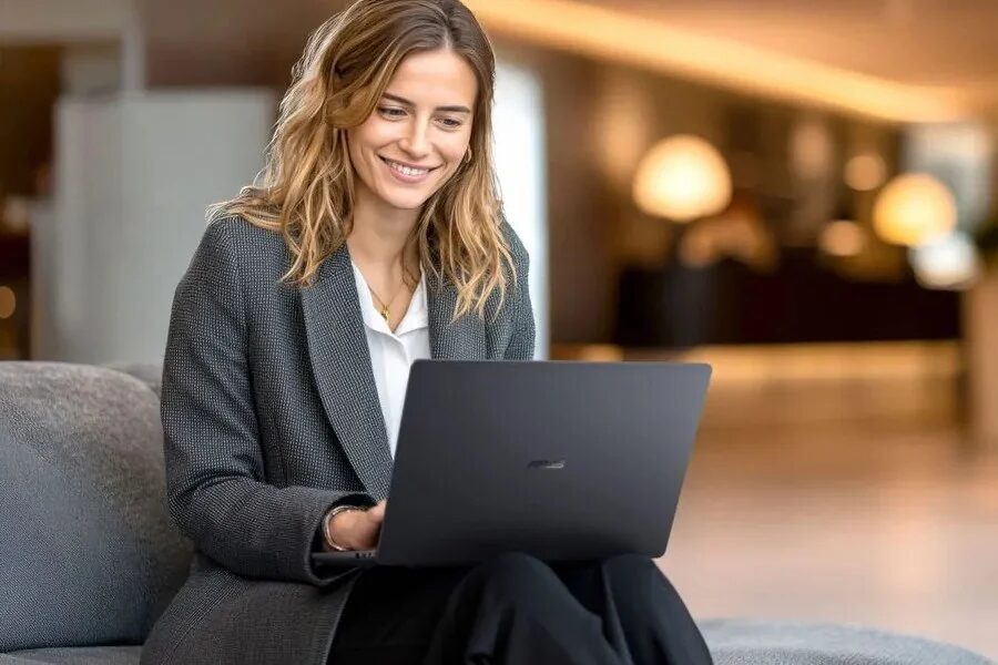 Женщина в деловом костюме работает с ноутбуком Asus ExpertBook B3 G1