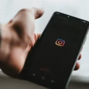 Человек держит смартфон с логотипом Instagram Plus