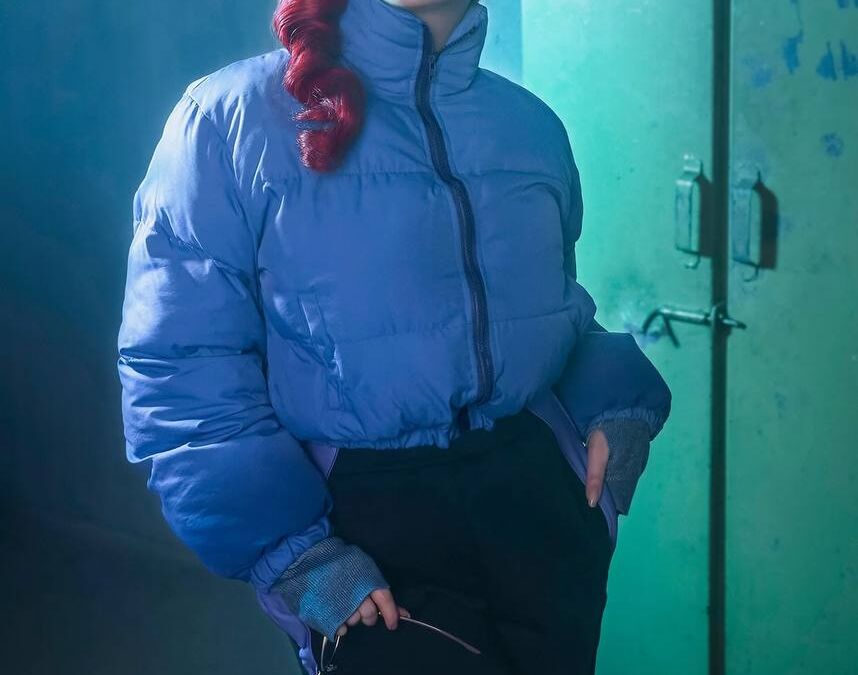 Модель в синей куртке и черных брюках косплей Анастасии Назаровой из Atomic Heart