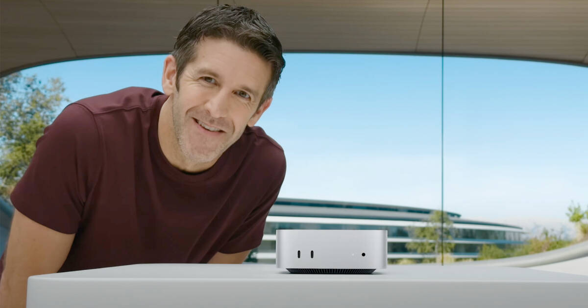 Человек улыбка рядом с устройством Apple CEO Джон Тернус