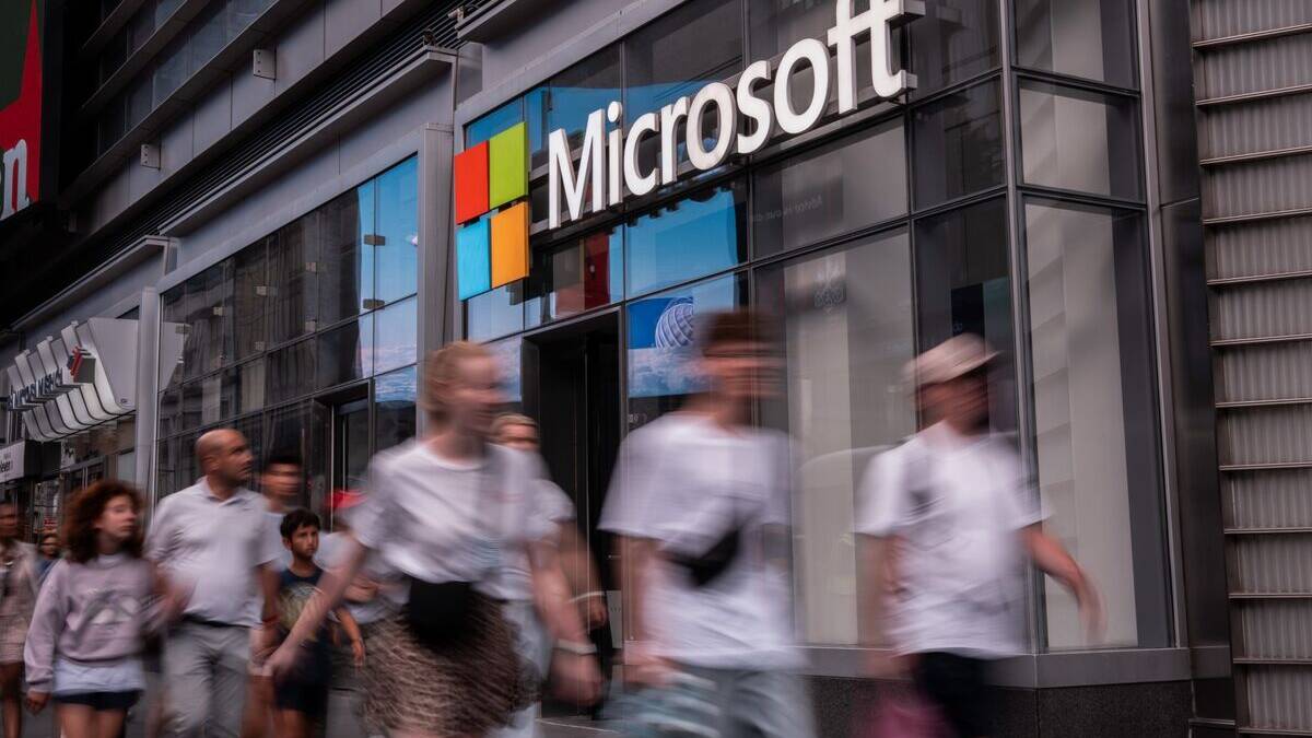Люди идут мимо магазина Microsoft на улице