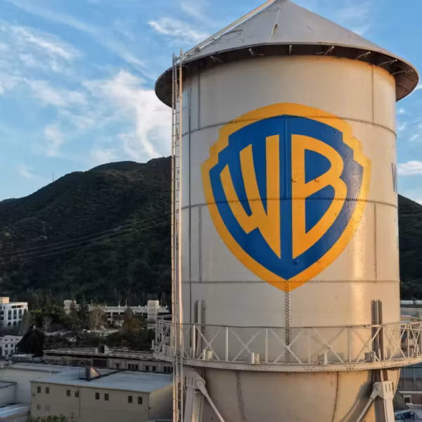 Башня с логотипом Warner Bros Discovery на фоне гор и неба