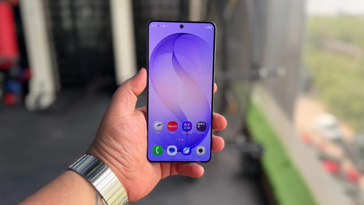 Держит смартфон Samsung Galaxy в руке предает