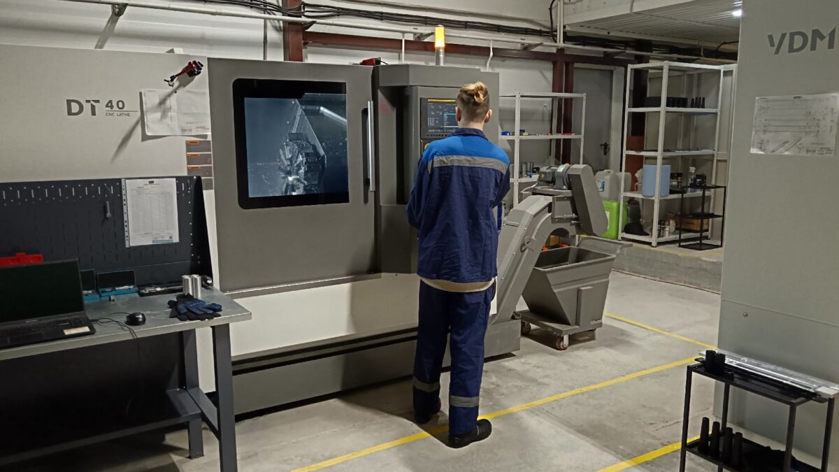 Мужчина в рабочей одежде рядом с станком Octava DM на новом заводе