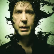 Мужчина с лицом в ужасной позе и волосами из черных пластиковых нитей