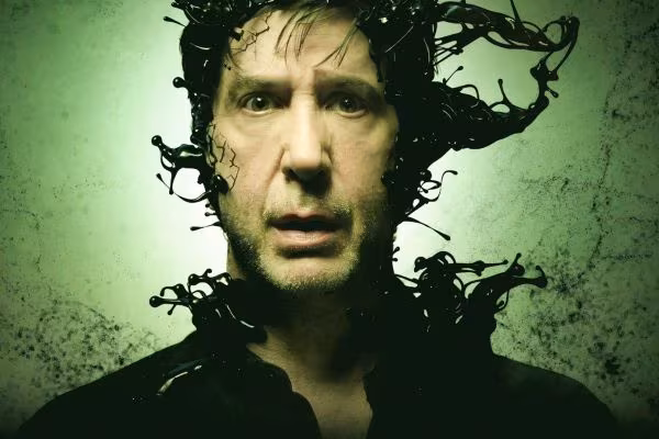 Мужчина с лицом в ужасной позе и волосами из черных пластиковых нитей