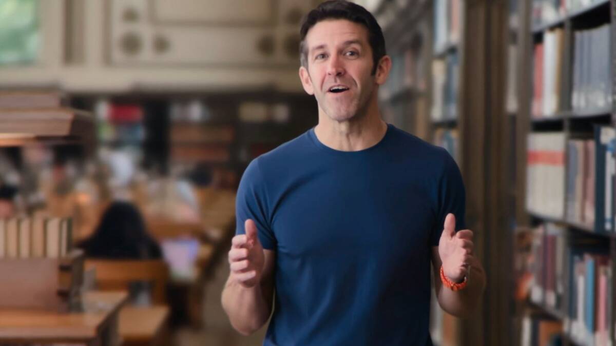 Мужчина говорит в библиотеке без пиджака