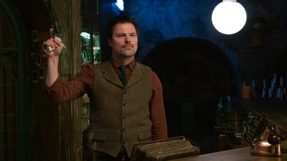 Мужчина стоит в баре с телефоном из статьи